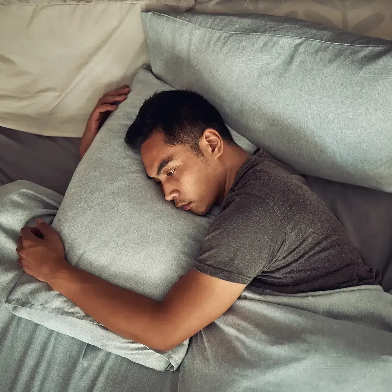 Man with insomnia struggling to fall asleep
